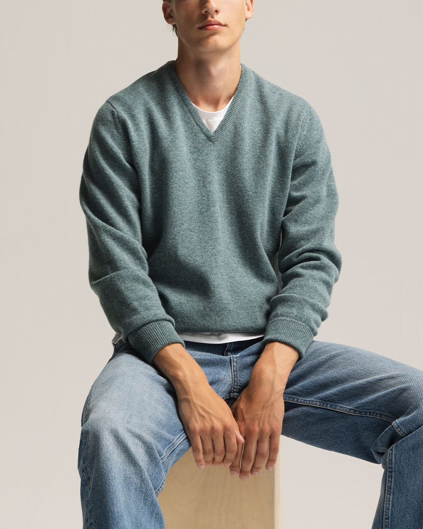 Grønn V-genser og lys blå jeans